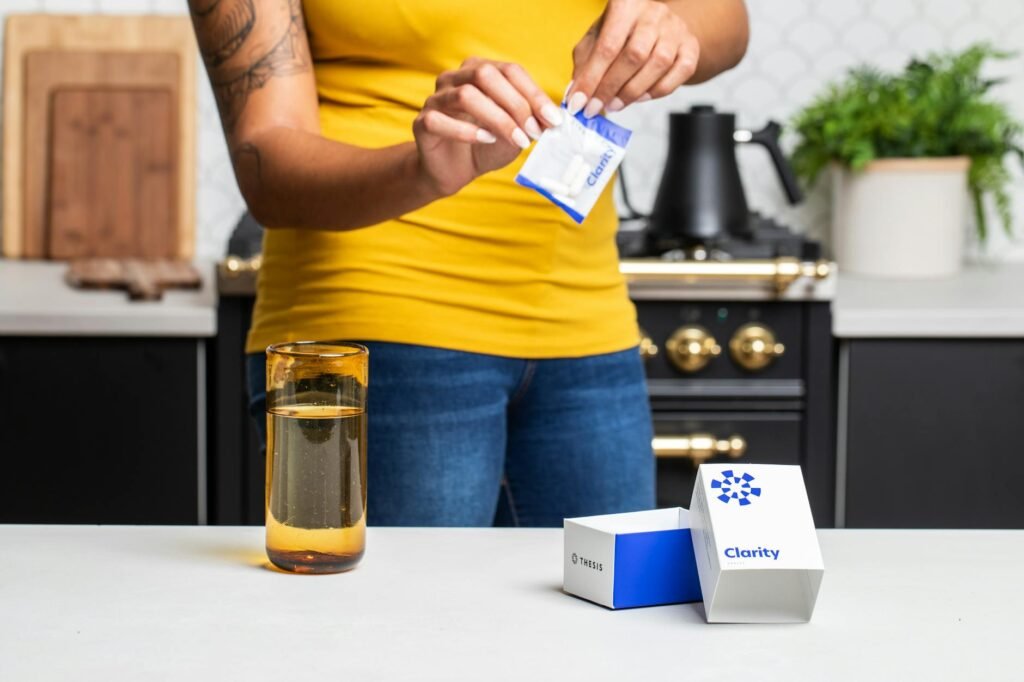 A person reading a Supplement Facts label carefully at a kitchen table.