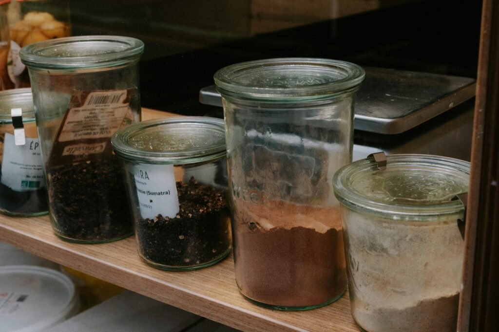 Labeled jars of dried herbs stored on a pantry shelf