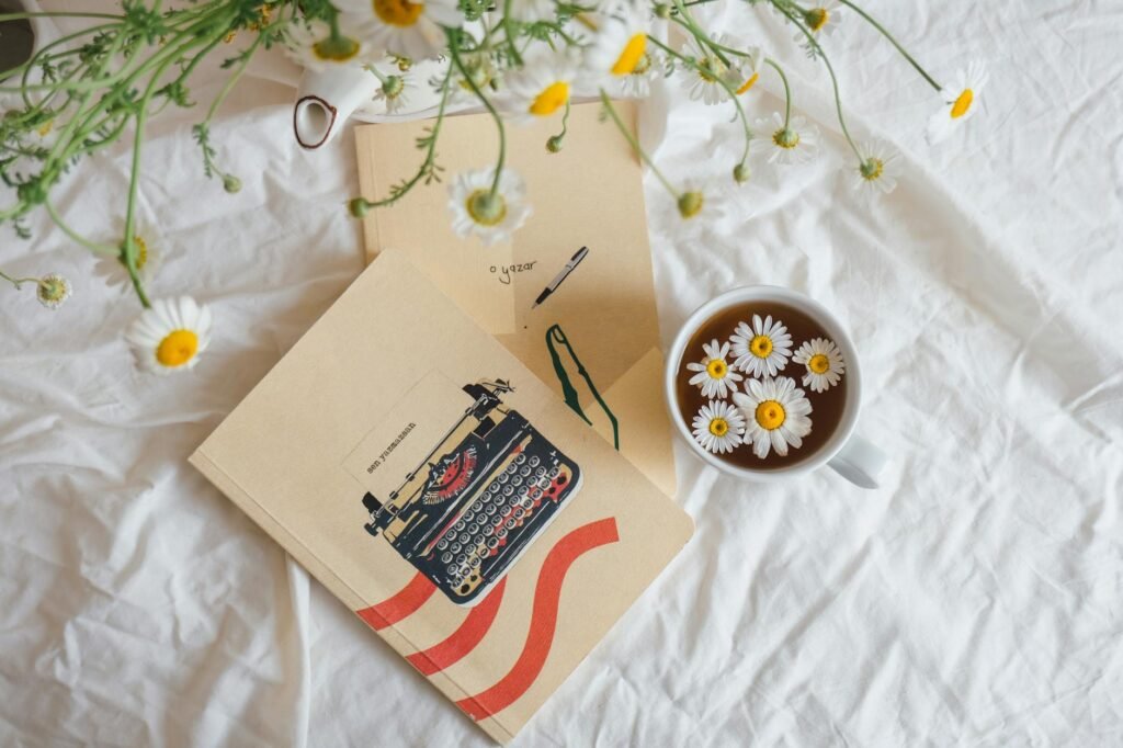 A notebook beside two tea cups set up for tracking a simple herbal trial.