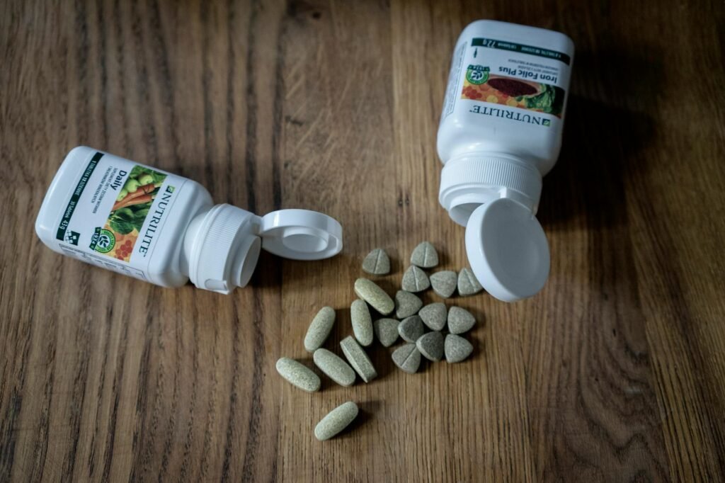 A single supplement bottle beside a notebook and pen on an organized table