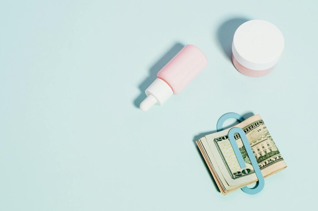 A calculator, receipts, and a few skincare products on a desk.