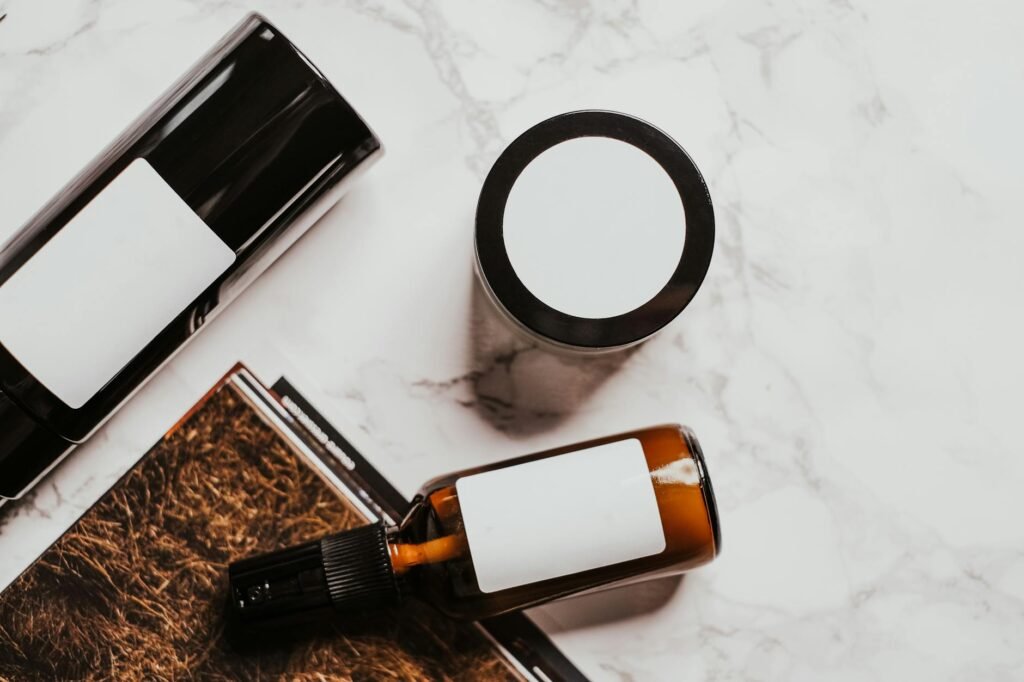 A person reading the ingredient label on skincare products beside a notebook.