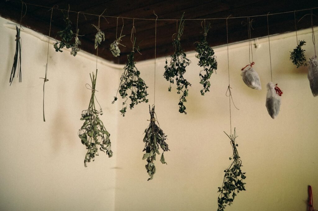Small labeled herb bundles hanging indoors to dry