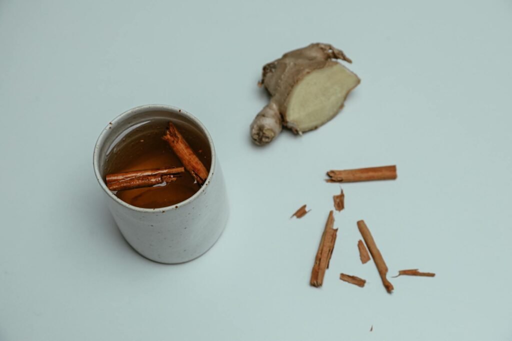 Chamomile tea, peppermint tea, ginger root, and cinnamon arranged on a table