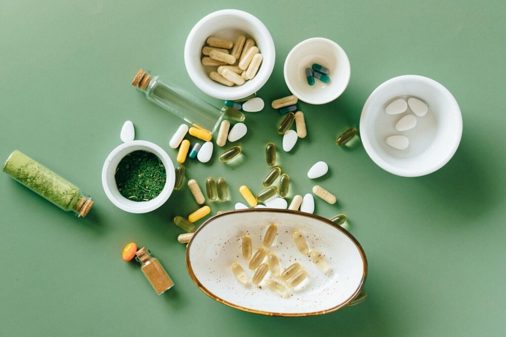 A notebook beside medicine and supplement bottles on a kitchen table