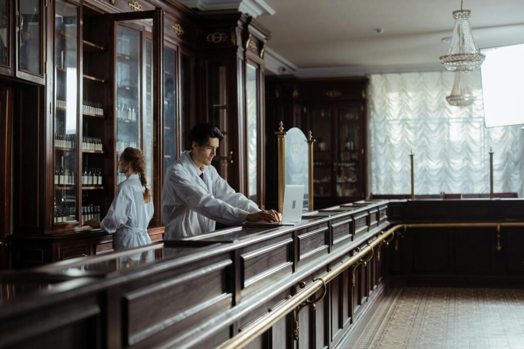 A pharmacist points to a supplement label while speaking with a customer.