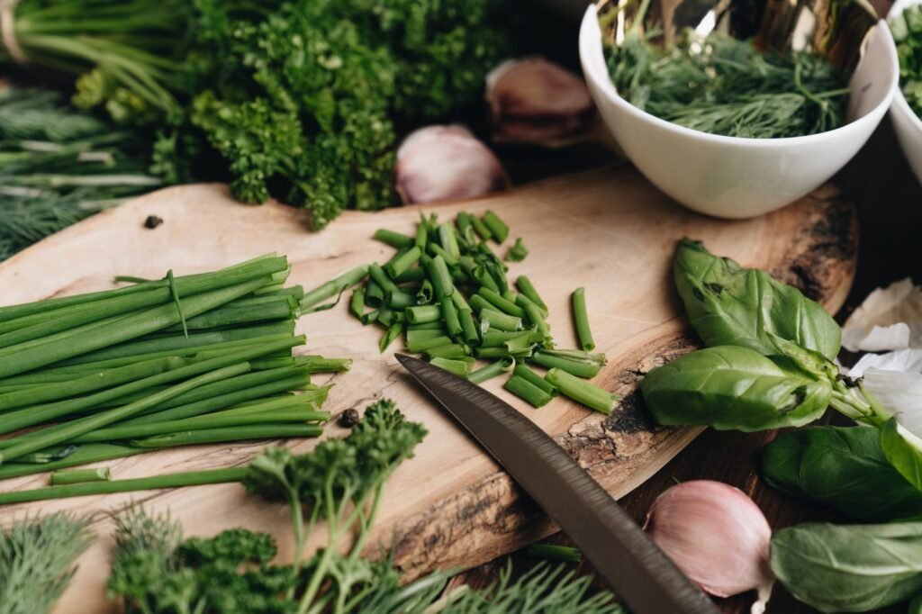 Fresh herbs laid out on a kitchen counter beside labeled storage containers.