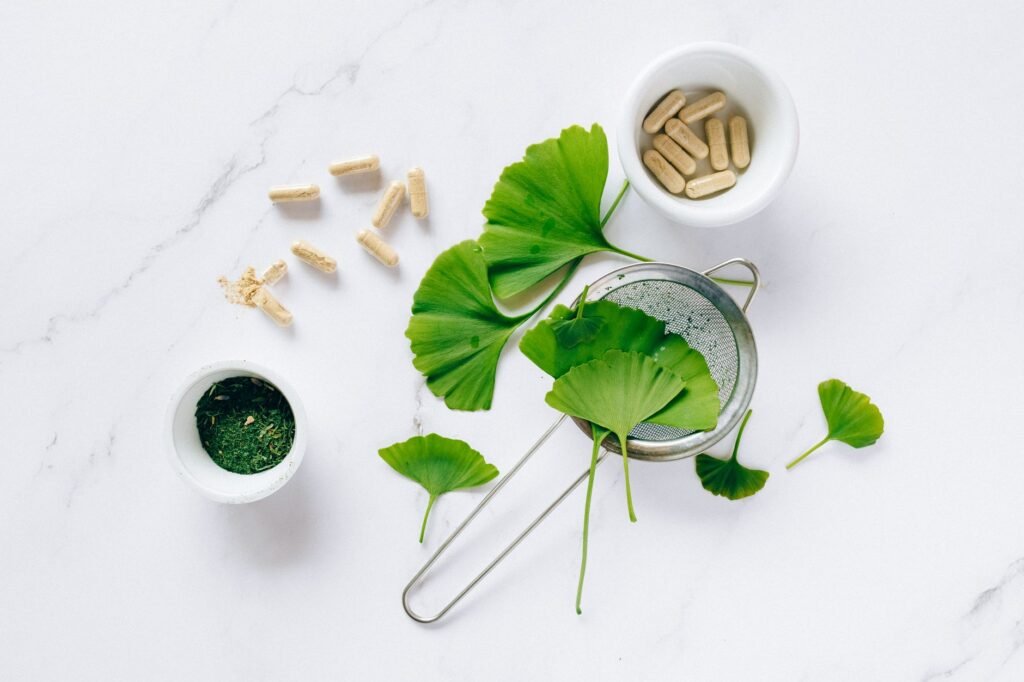 Capsules, a jar of powder, a tincture bottle, and herbal tea arranged side by side on a table