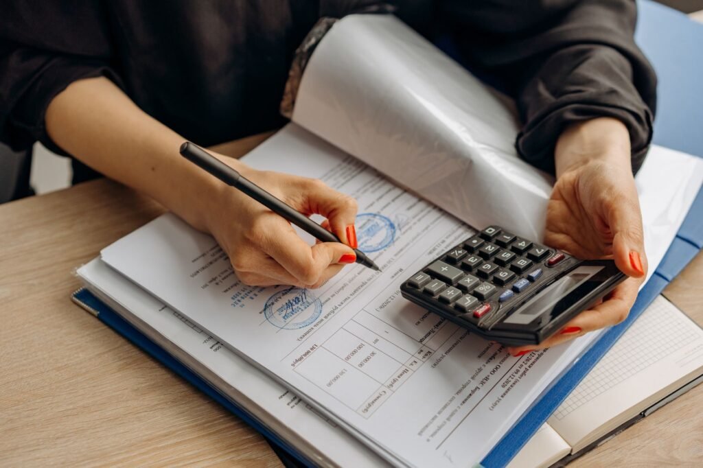 Calculator and notebook beside supplement bottles and a receipt